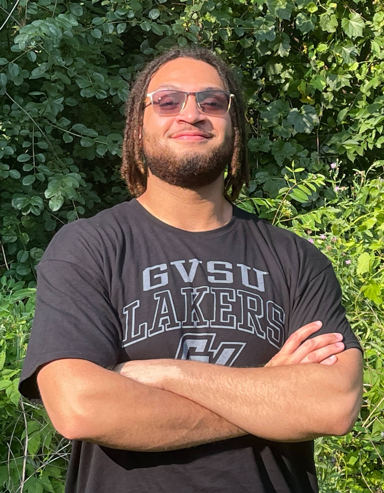 Dante givens posing with crossed arms in a GVSU t-shirt